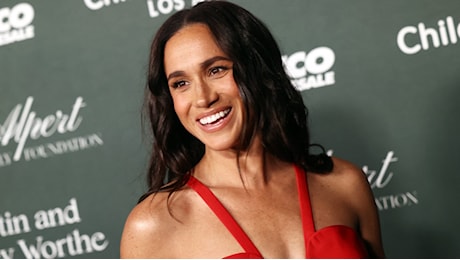 Meghan Markle, la serata di gala si tinge di rosso: ricicla l’abito con la maxi scollatura