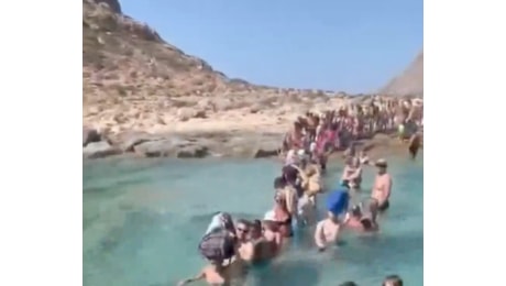 Niente molo, turisti costretti a entrare in acqua con i bagagli sulla testa per sbarcare