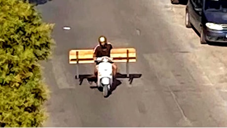 Ruba una panchina e la carica sullo scooter: le immagini sui social